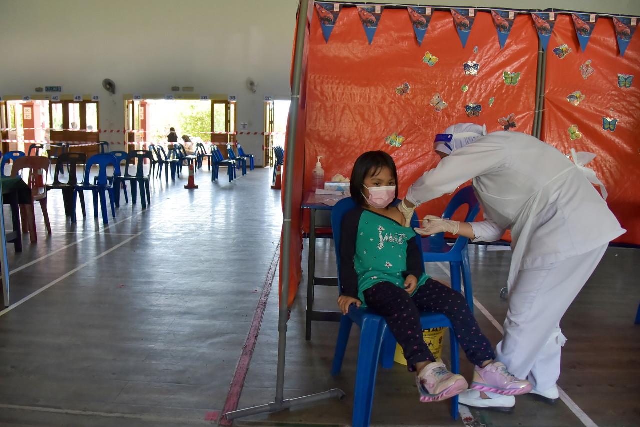 A health worker administers a dose of Covid-19 vaccine to a child at an otherwise empty vaccination centre in Labuan on Feb 18. Photo: Bernama