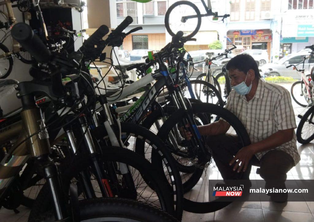 Zulkifli Abdul Hamid memeriksa basikal di kedainya di Bandar Maharani, Muar.