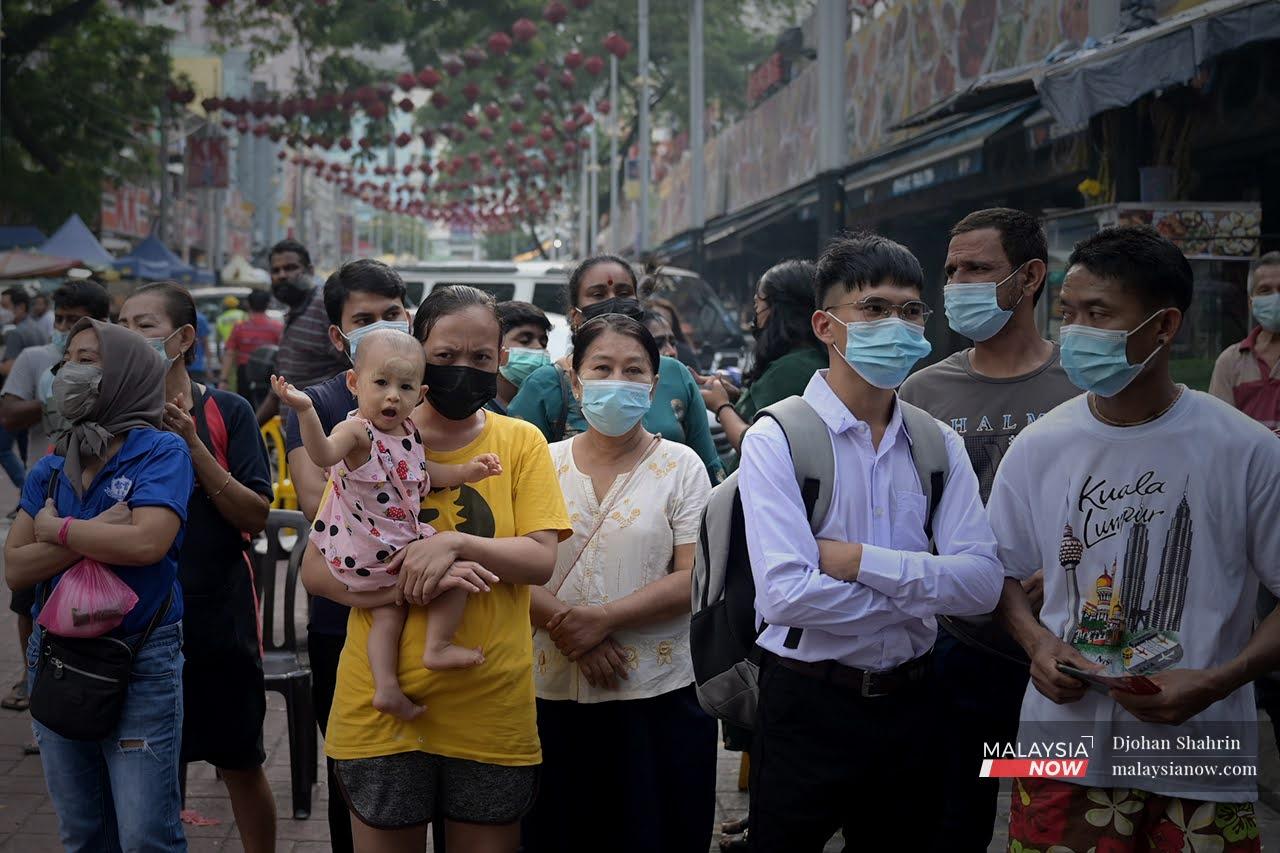 Orang ramai memakai pelitup muka bagi melindungi diri dari Covid-19 di ibu negara Kuala Lumpur.