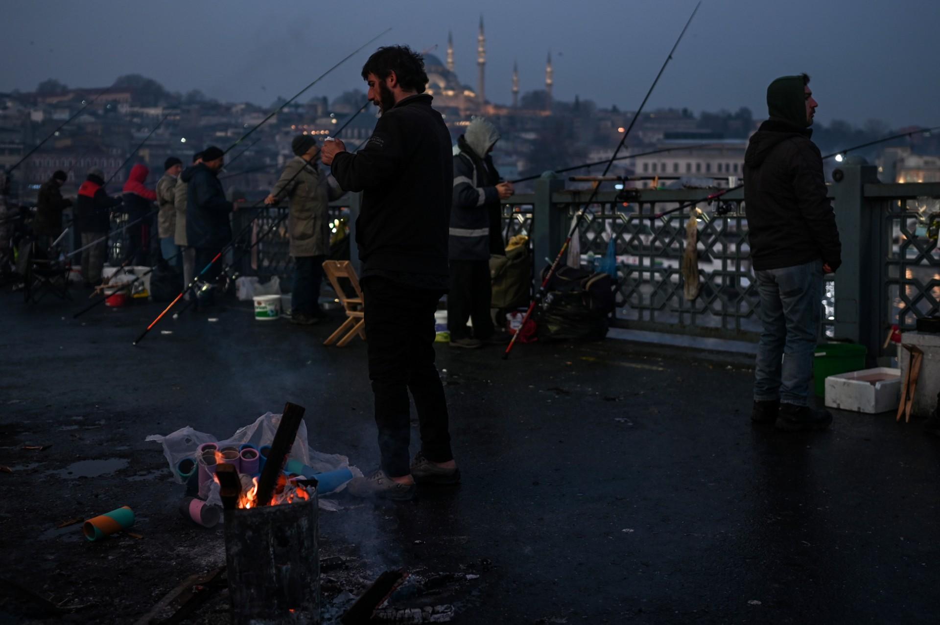 Fishermen fish on Galata bridge during the early morning in Istanbul on Feb 16. Turkey has been conducting a delicate balancing act since the Russian invasion of Ukraine last Thursday. Photo: AFP