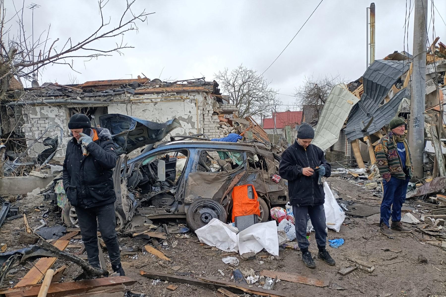 Three men stand in the rubble in Zhytomyr on March 2, following a Russian bombing the day before. Photo: AFP