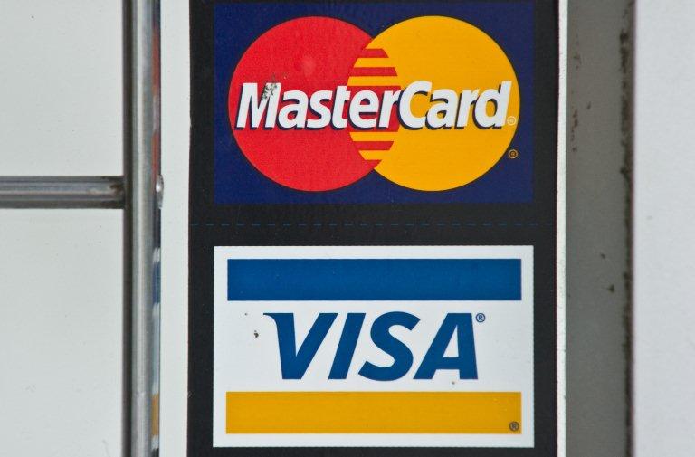 In this file photo taken on March 30, 2012, Visa and MasterCard credit card logos are seen in a store window in Washington DC. Photo: AFP