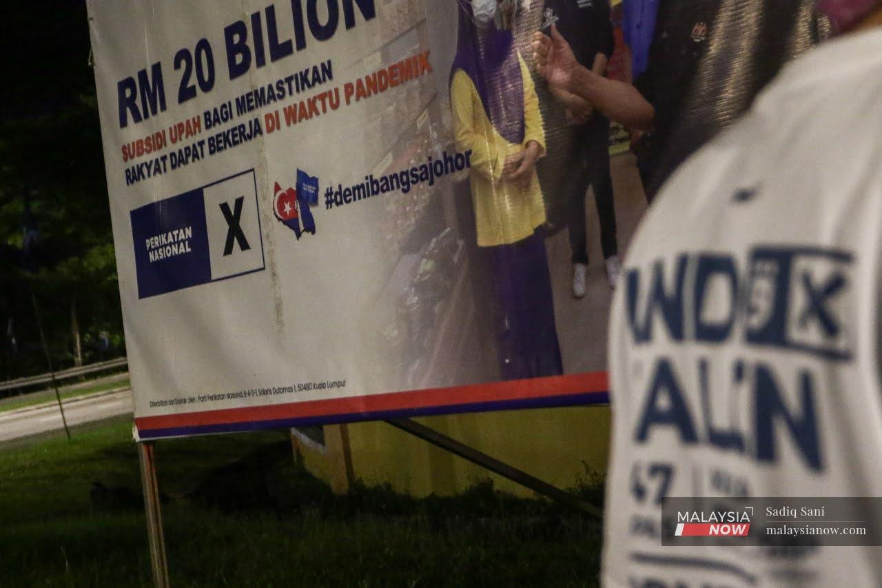 Volunteers from Perikatan Nasional set up a billboard near Larkin ahead of the Johor election on March 12, which PAS is contesting under the PN banner.
