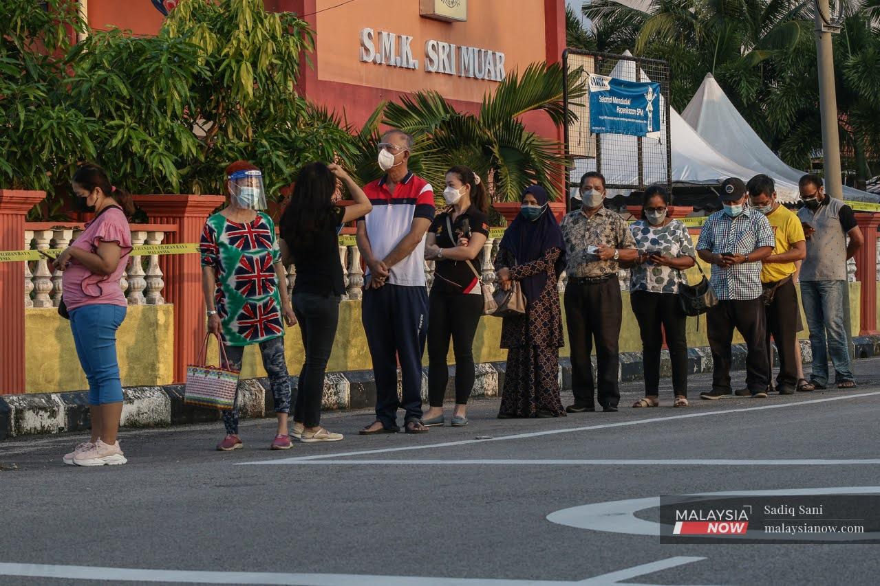 Pengundi DUN Maharani beratur di pusat pengundian SMK Sri Muar bagi membuang undi pada PRN Johor hari ini.
