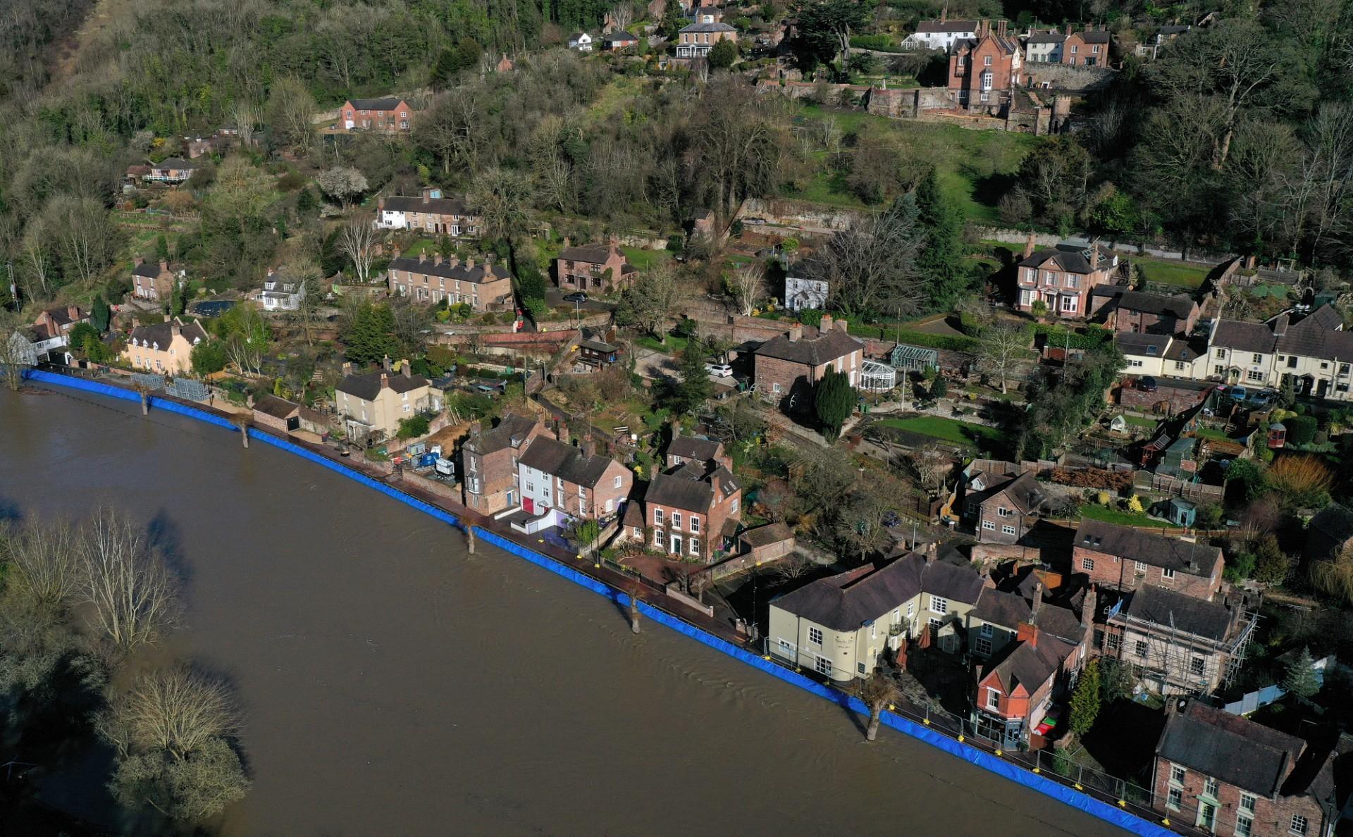 An aerial view shows temporary flood defences, to protect homes and businesses, along the burst banks of the River Severn after the river burst its banks in Ironbridge, central England, on Feb 22. Britain will pay people US$456 a month if they can offer refugees a spare room or property for a minimum period of six months. Photo: AFP