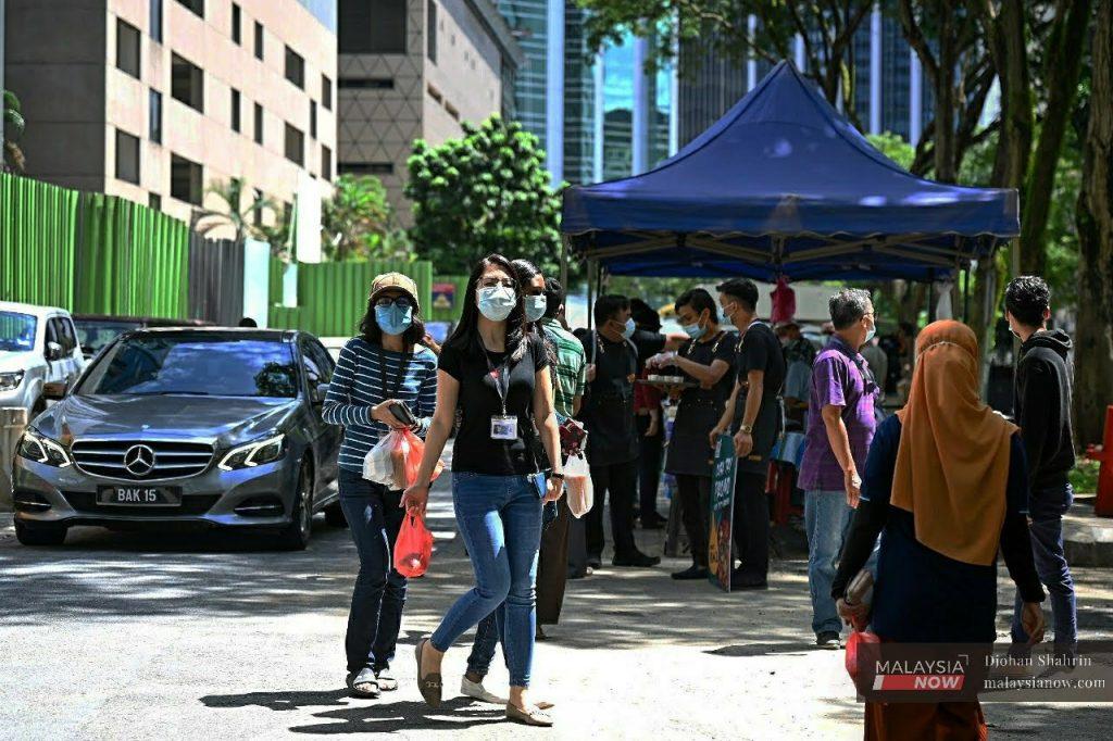 People wearing face masks to curb the spread of Covid-19 walk at Jalan Tengah in Kuala Lumpur.