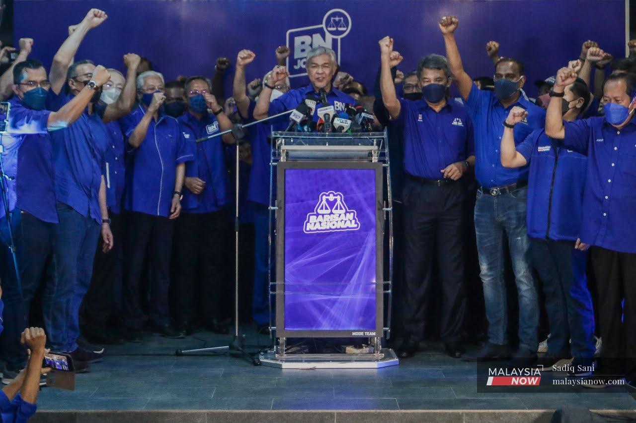 Barisan Nasional chairman Ahmad Zahid Hamidi holds up his fist in a gesture of triumph after the Johor state election, together with other leaders including Prime Minister Ismail Sabri Yaakob (fourth from left).