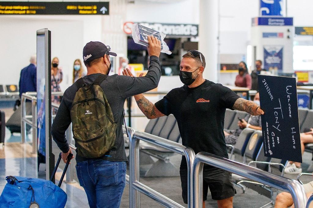 Passengers and loved ones reunite at the arrivals hall on the first day of New Zealanders returning from Australia after the border reopened for travellers observing home self-isolation rules, at the Auckland international airport on Feb 28. Photo: AFP