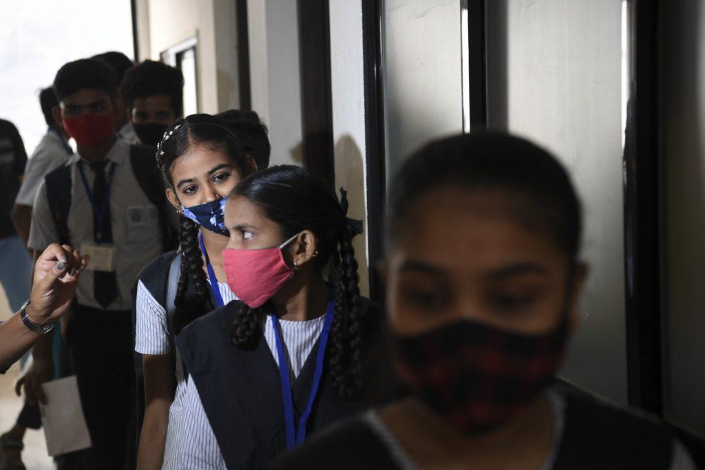 Youths stand in a queue as they wait for their turn to get inoculated with a dose of a Covid-19 vaccine during a vaccination drive for people in the 15-18 age group, in Mumbai on Jan 3. Photo: AFP