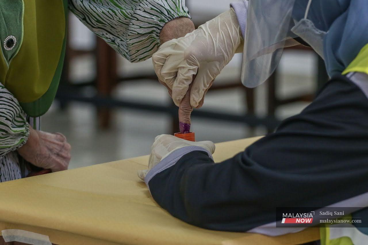 Pengundi mencelup dakwat di jari selepas membuang undi pada Pilihan Raya Negeri Johor baru-baru ini.