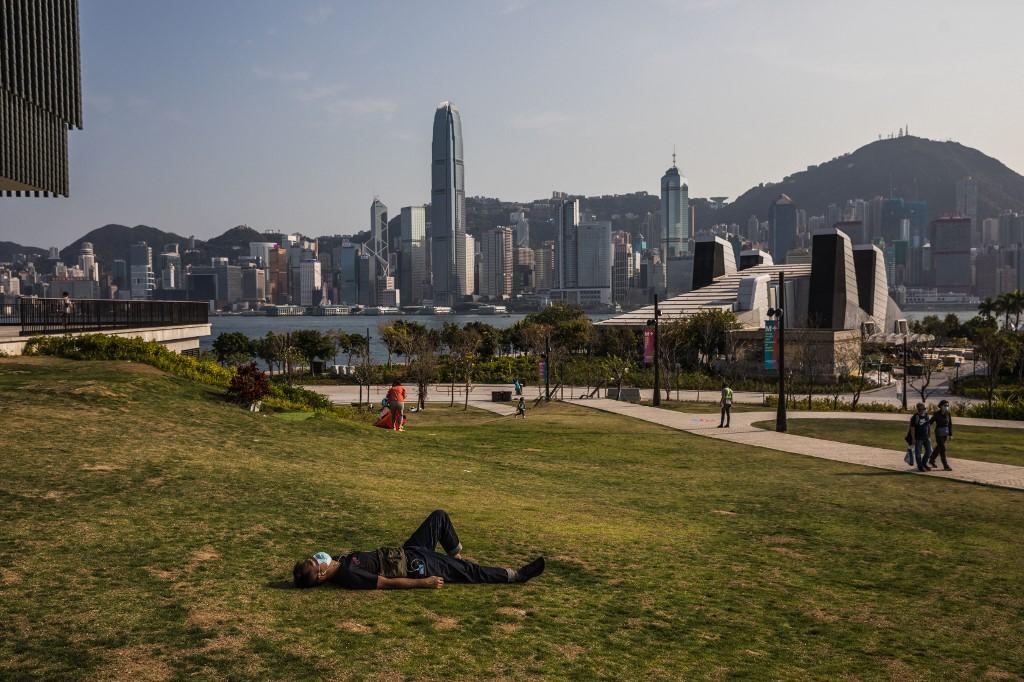 A man rests in a park next to Victoria Harbour in Hong Kong on March 14. Photo: AFP