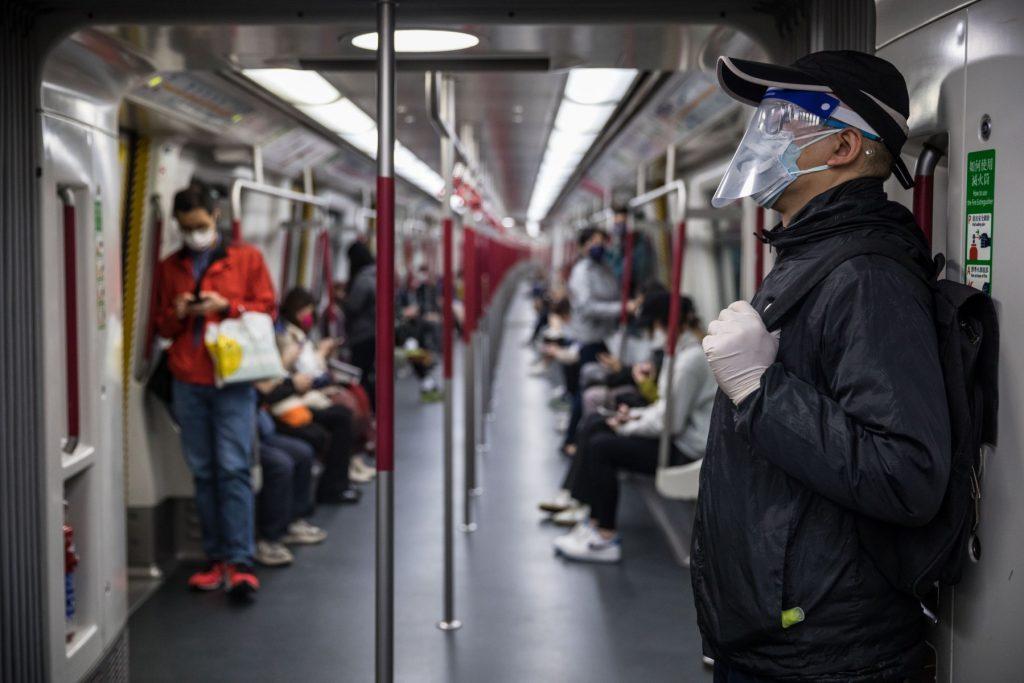 A man wearing a face shield and gloves commutes on a train in Hong Kong on March 8, amid the city's worst-ever Covid-19 outbreak. Photo: AFP