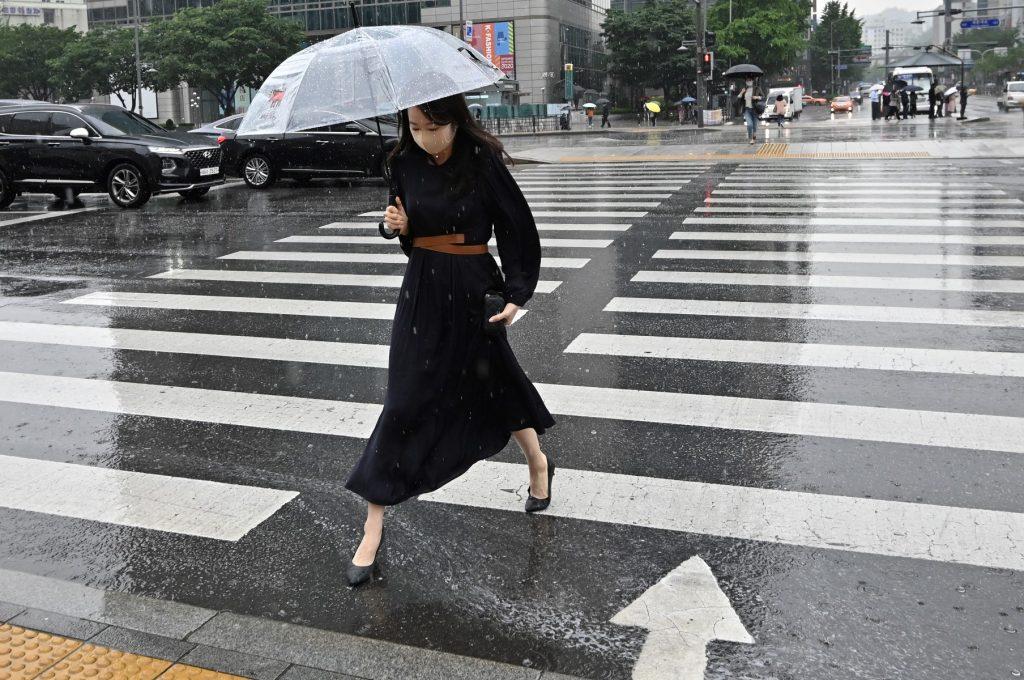 A woman holding an umbrella crosses a road in central Seoul on June 2, 2020. Photo: AFP
