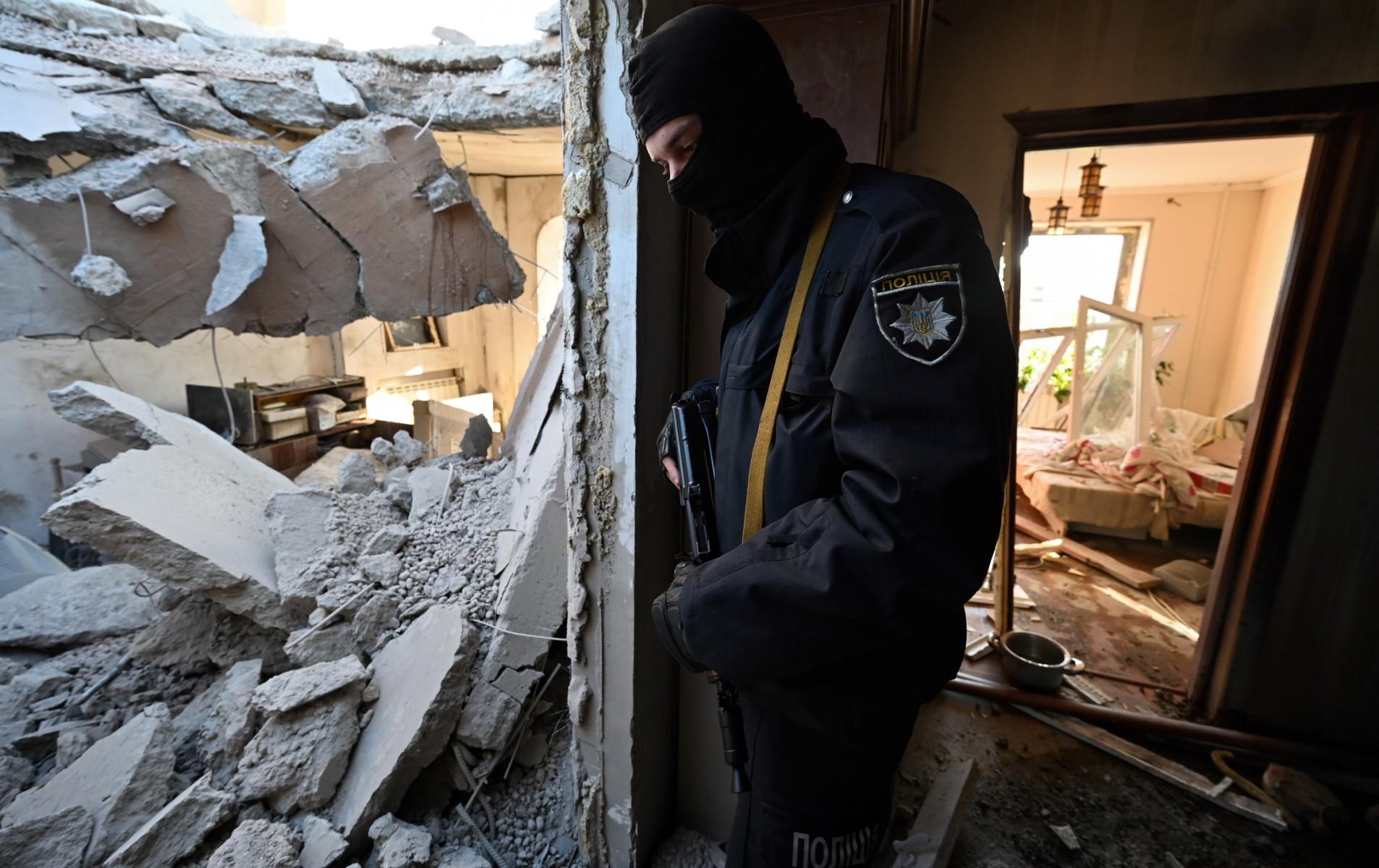 A police officer stands inside a destroyed apartment at a damaged housing block after it was hit by debris from a downed rocket in Kyiv on March 17, as Russian forces press in on the Ukrainian capital. Photo: AFP
