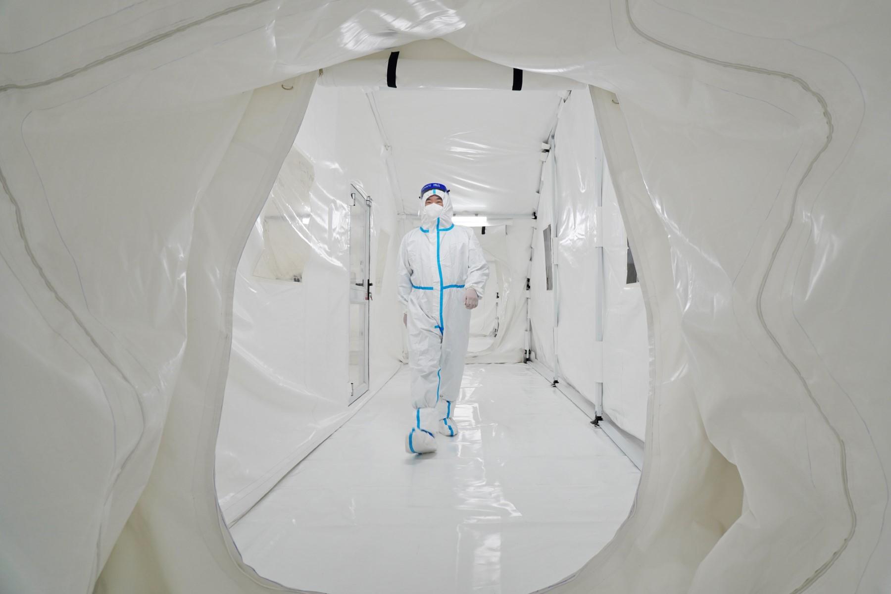 This photo taken on March 17 shows a staff member wearing personal protective equipment walking at the Fire Eye laboratory, a temporary Covid-19 coronavirus testing facility, before it opens in Yantai in China's eastern Shandong province. Photo: AFP