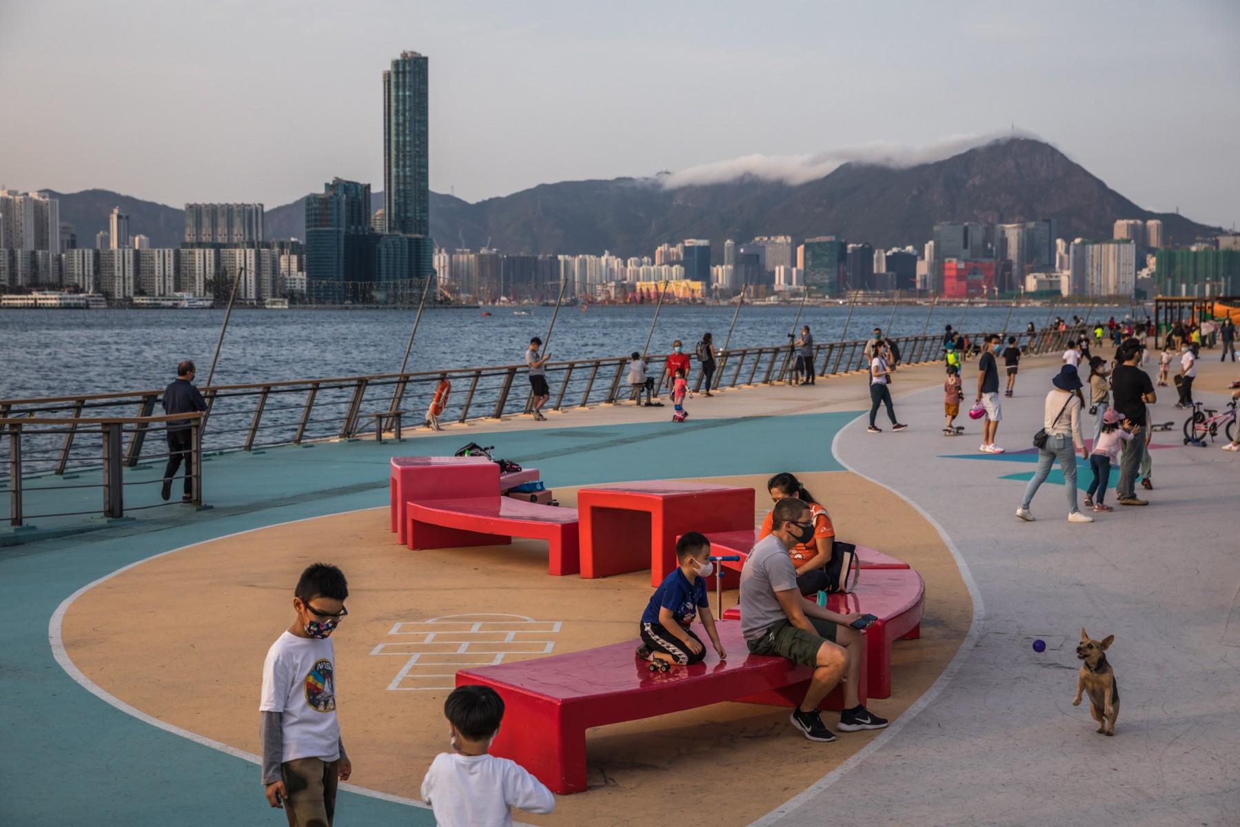 People visit a promenade next to Victoria Harbour in Hong Kong on March 15. Photo: AFP