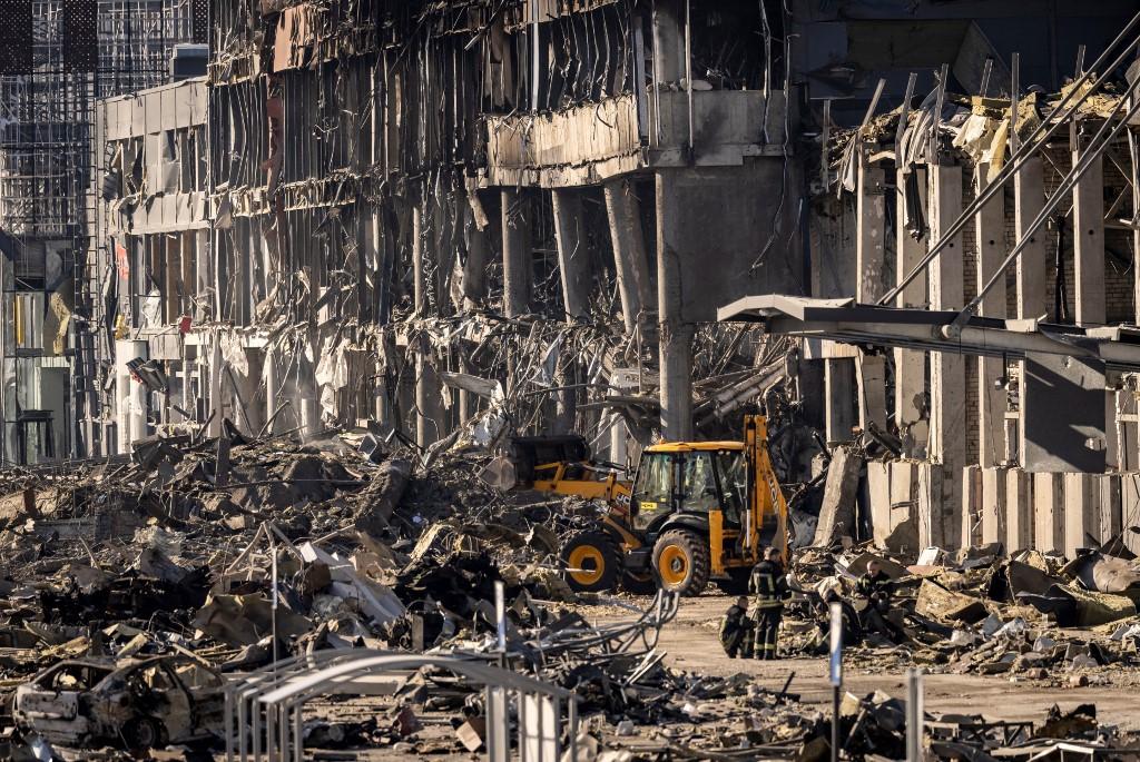 Ukrainian firefighters work amid the rubble of the Retroville shopping mall, a day after it was shelled by Russian forces in a residential district in the northwest of the Ukranian capital Kyiv on March 21. Photo: AFP