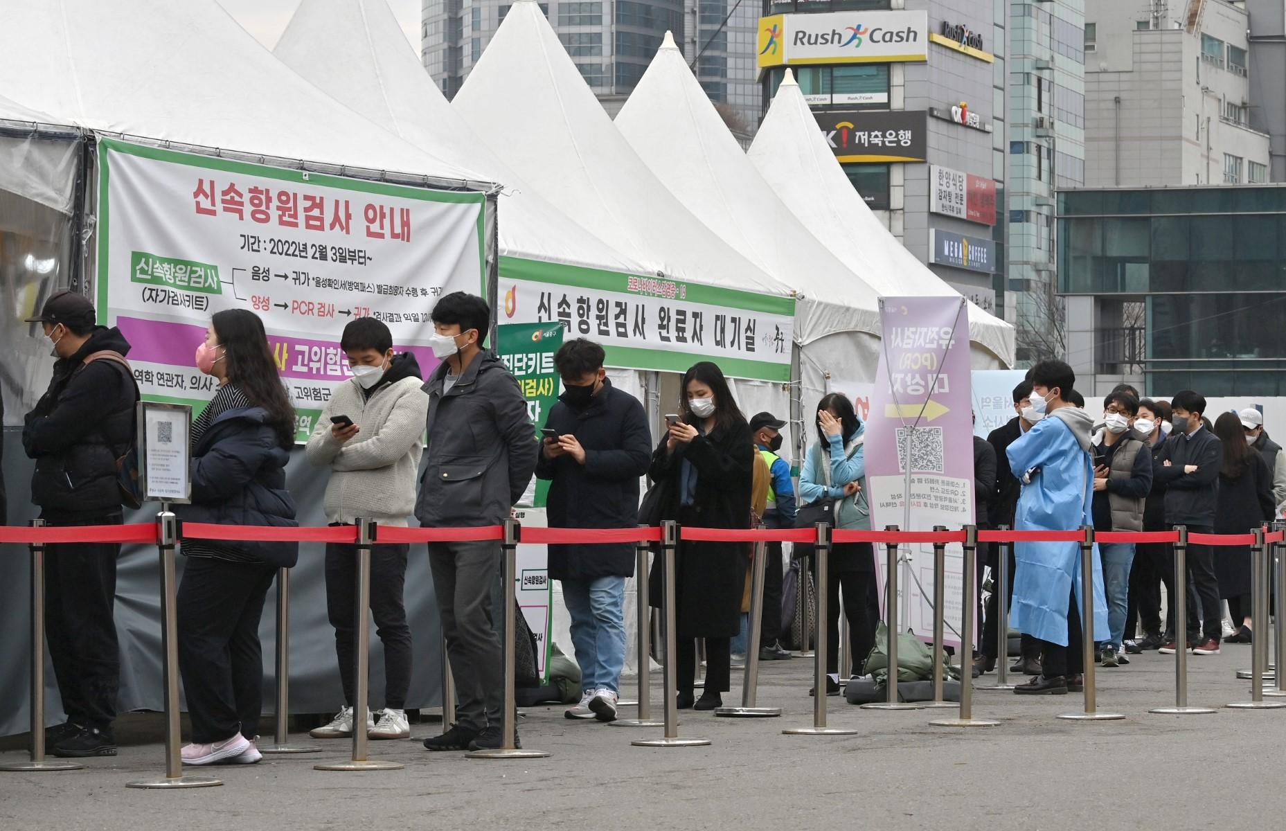 People wait in line to be tested for the Covid-19 coronavirus at a virus testing centre in Seoul on March 17, after South Korea's daily infections rose sharply to hit a new high of over 600,000. Photo: AFP