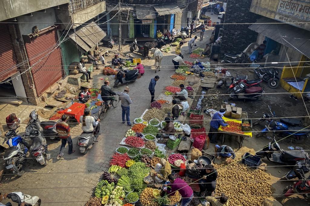 In this picture taken on Feb 5, people shop at a vegetable market along a street in Mathura. Photo: AFP