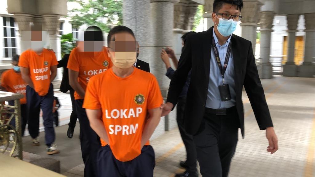 The nine suspects at the Magistrate's Court in Putrajaya today.