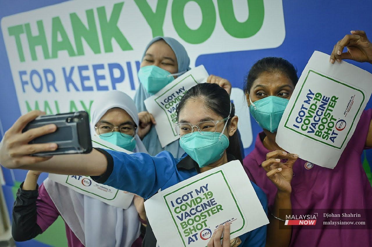 Health workers pose for a photo after completing their third dose of Pfizer vaccine at KPJ Tawakkal in Jalan Pahang, Kuala Lumpur.