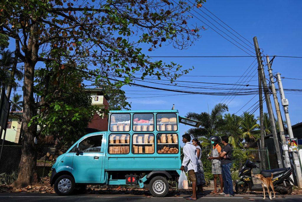 People buy bread from a vendor on a street in Colombo in this March 27, 2020 file picture. The South Asian nation of 22 million people is facing its worst economic meltdown since independence from Britain in 1948 after its foreign reserves hit rock bottom. Photo: AFP