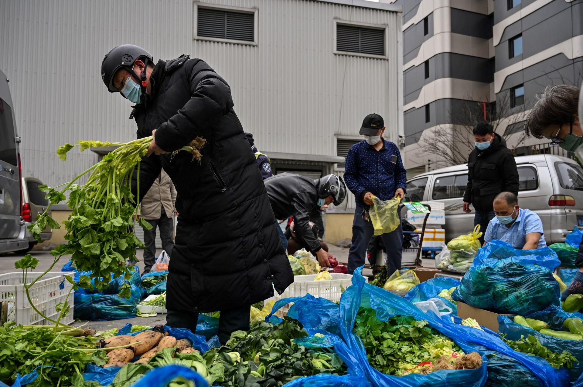 People buy vegetables on a street next to a local market in Jing'an district, in Shanghai on March 31. Photo: AFP