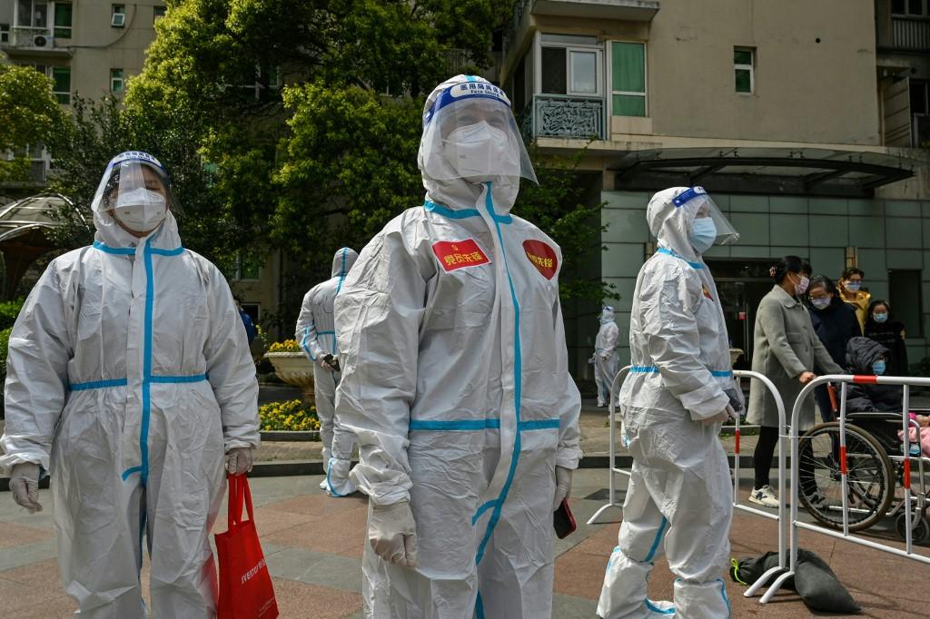 Workers and volunteers look on in a compound where residents are tested for the Covid-19 coronavirus during the second stage of a pandemic lockdown in Jing' an district in Shanghai on April 1. Photo: AFP