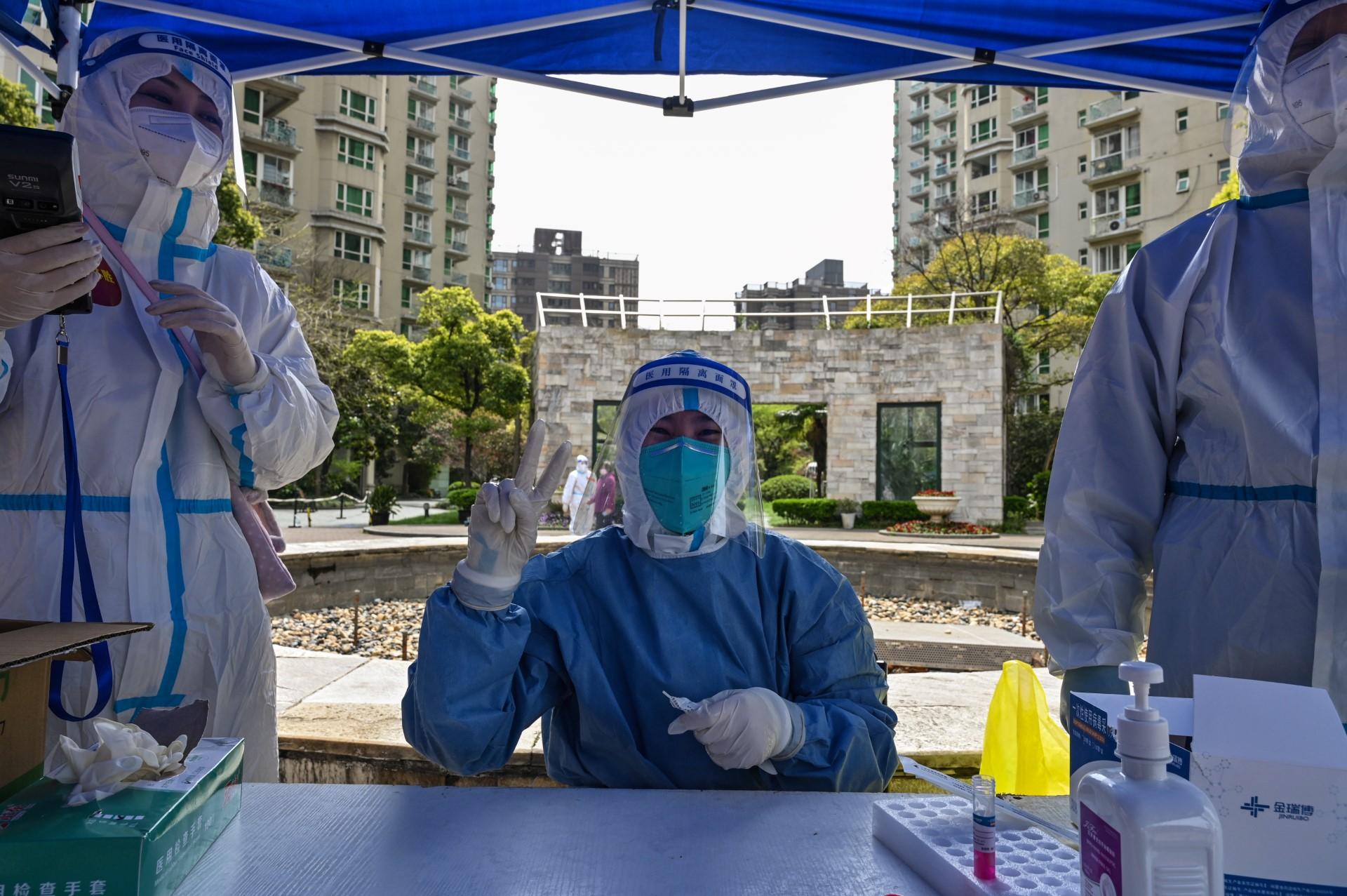 A health worker gestures while preparing to conduct a swab test at a residential compound during the second stage of a Covid-19 lockdown in Jing'an district in Shanghai on April 1. Photo: AFP