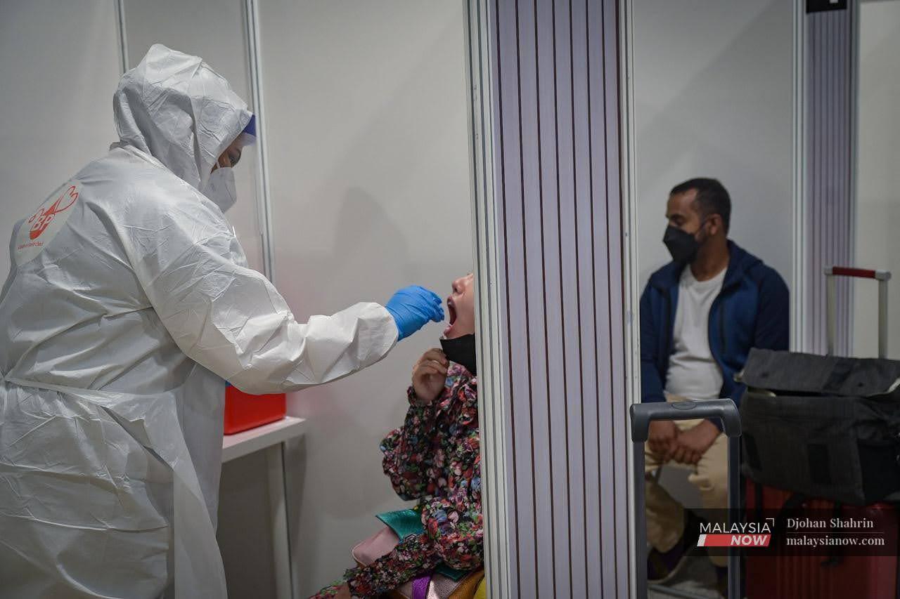 Passengers are tested for Covid-19 upon their arrival at KLIA in Sepang, as the country's borders reopen after years of pandemic restrictions.