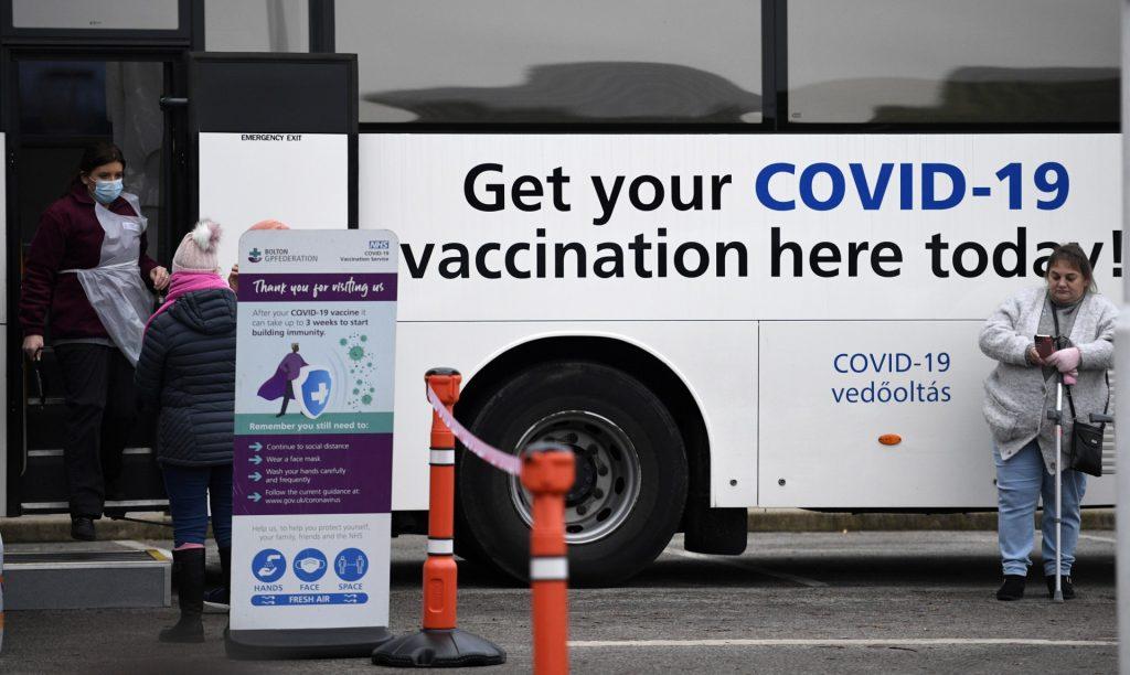 Members of the public wait to receive their Covid-19 vaccine or booster at a National Health Service bus outside a supermarket in the town of Farnworth, near Manchester in north-west England on Dec 20, 2021. Photo: AFP