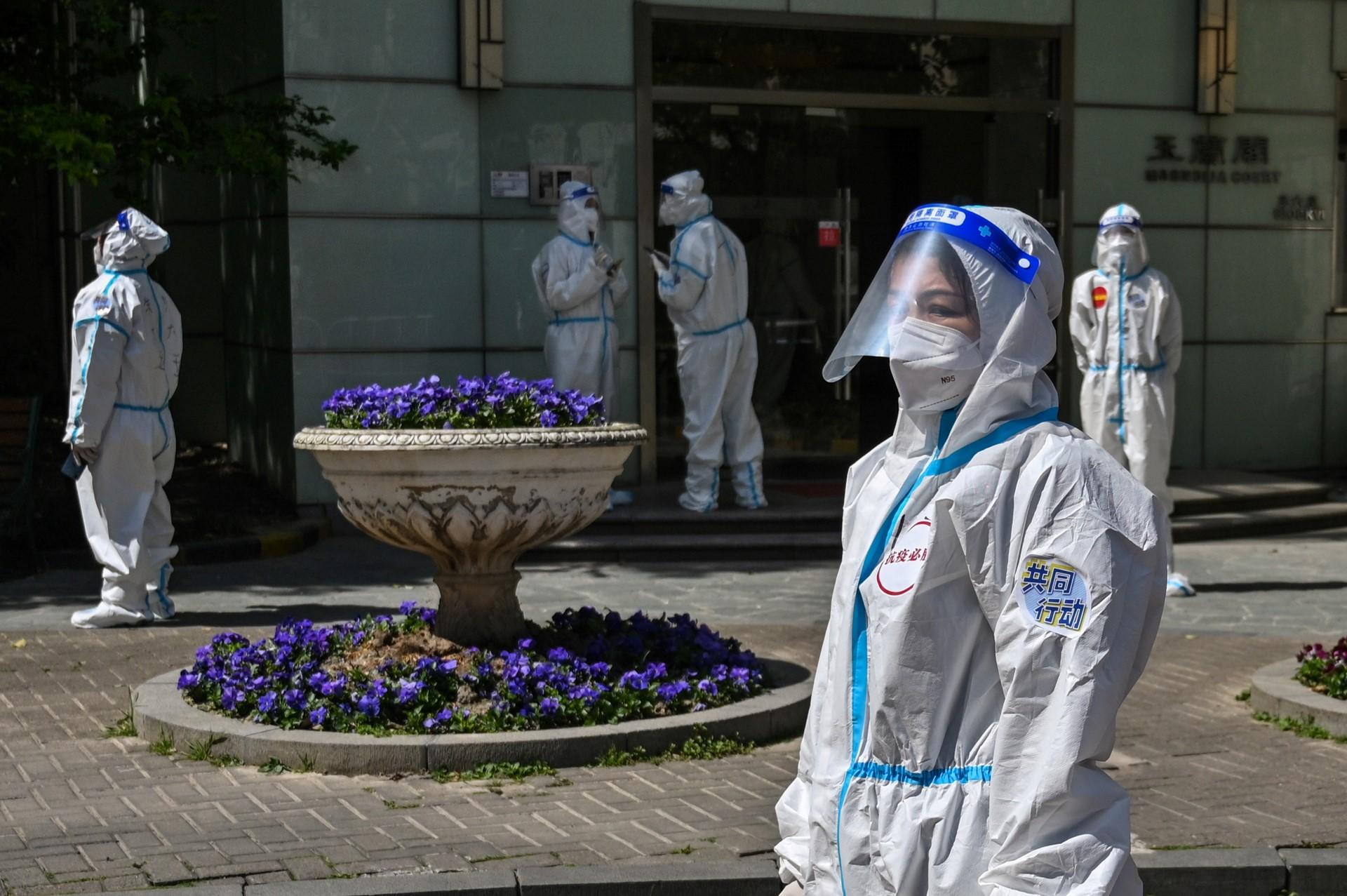 Workers and volunteers look on in a compound where residents are tested for Covid-19 during the second stage of a pandemic lockdown in the Jing'an district in Shanghai on April 4. Photo: AFP