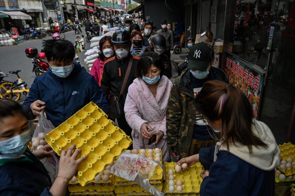 People queue to buy eggs next to a market in Yangpu district, in Shanghai on March 28. Photo: AFP