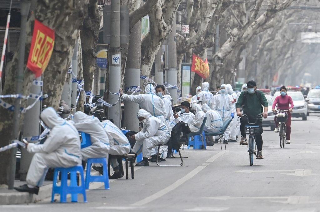 Workers are seen wearing protective clothes next to some lockdown areas after the detection of new cases of Covid-19 in Shanghai on March 14. Photo: AFP