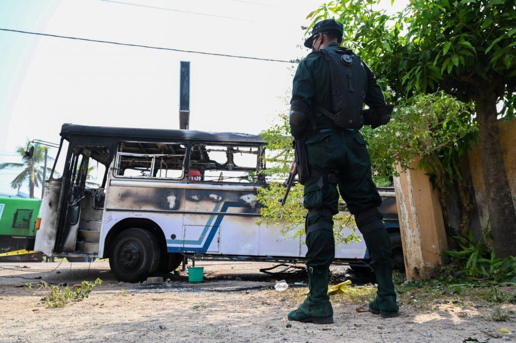 A soldier guards an area next to a burnt-out bus near the Sri Lankan president's home in Colombo on April 1. Photo: AFP