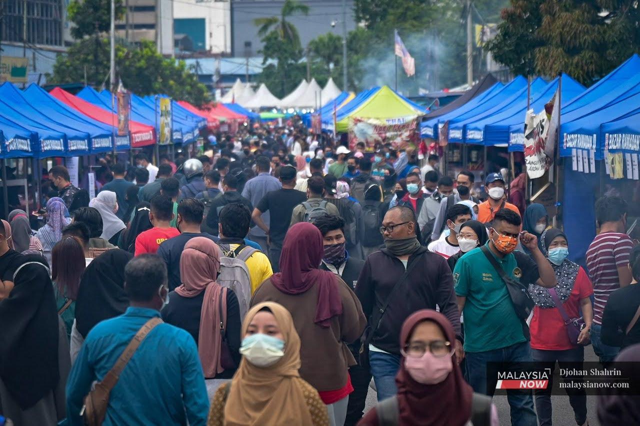 People wearing face masks visit the Jalan Raja Alang Ramadan bazaar in Kampung Baru, Kuala Lumpur. The use of face masks is mandatory under Malaysia's Covid-19 prevention measures.