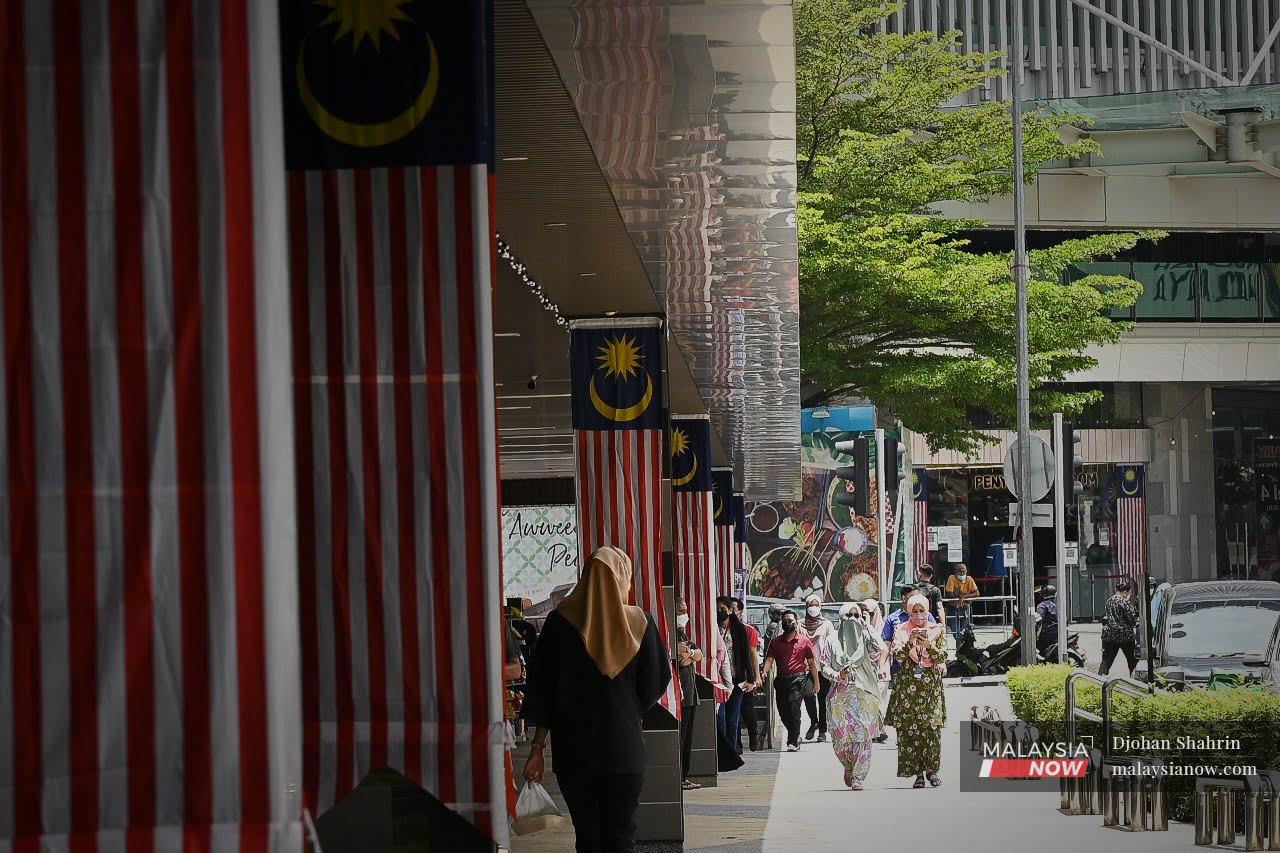 Orang ramai melintasi deretan Jalur Gemilang di  Jalan Tuanku Abdul Rahman. Pakar ekonomi bimbang penggunaan bahasa Melayu di peringkat global akan menghasilkan kesan negatif secara tidak langsung kepada pertumbuhan ekonomi.