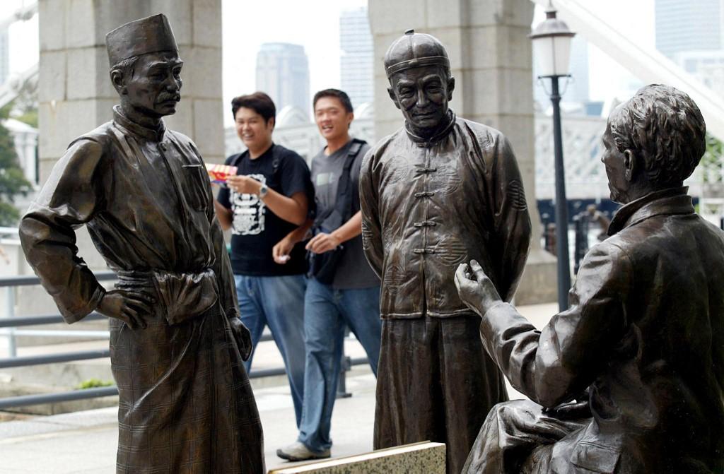 Bronze statues depicting an ethnic Malay and Chinese along the river in Singapore. Malays, one of three major racial groups in Singapore, make up about 13.5% of the island state. Photo: AFP
