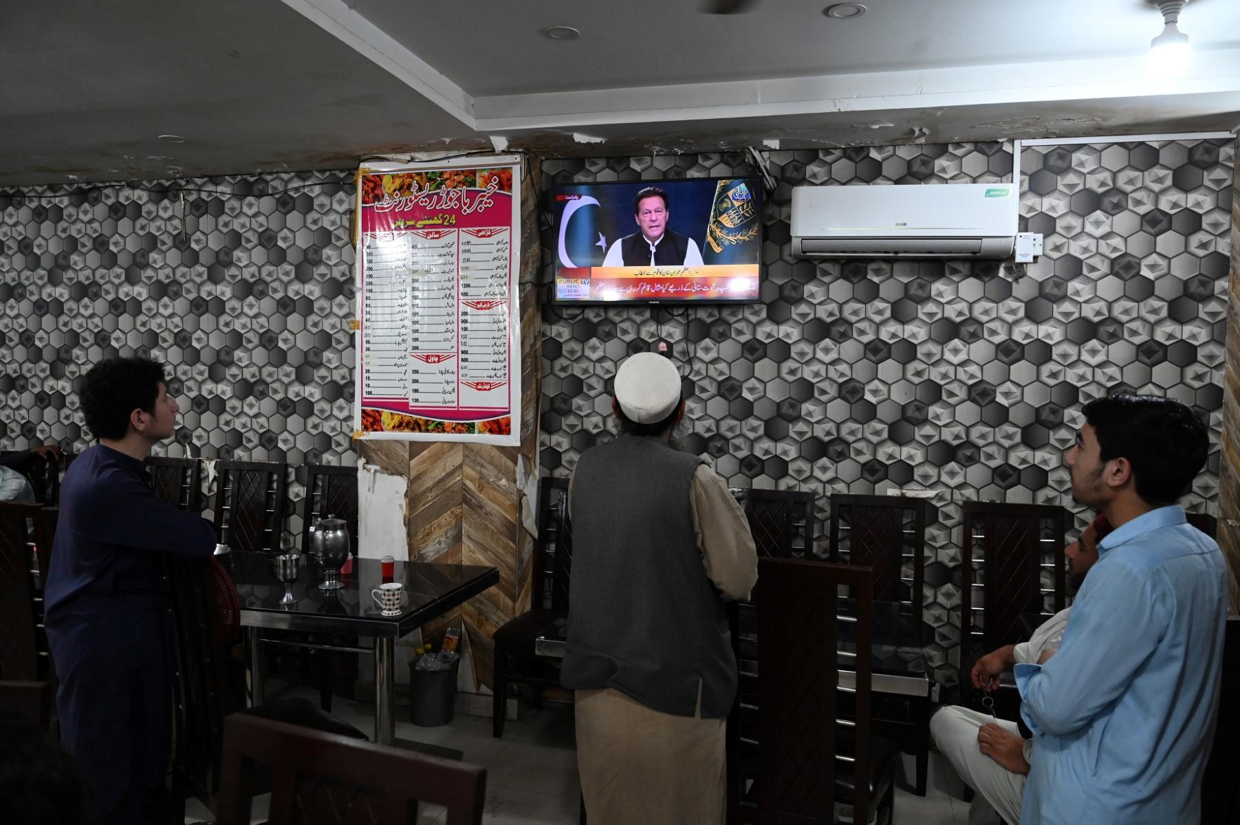 People listen to Pakistan's Prime Minister Imran Khan addressing the nation on television at a restaurant in Islamabad on April 8. Photo: AFP