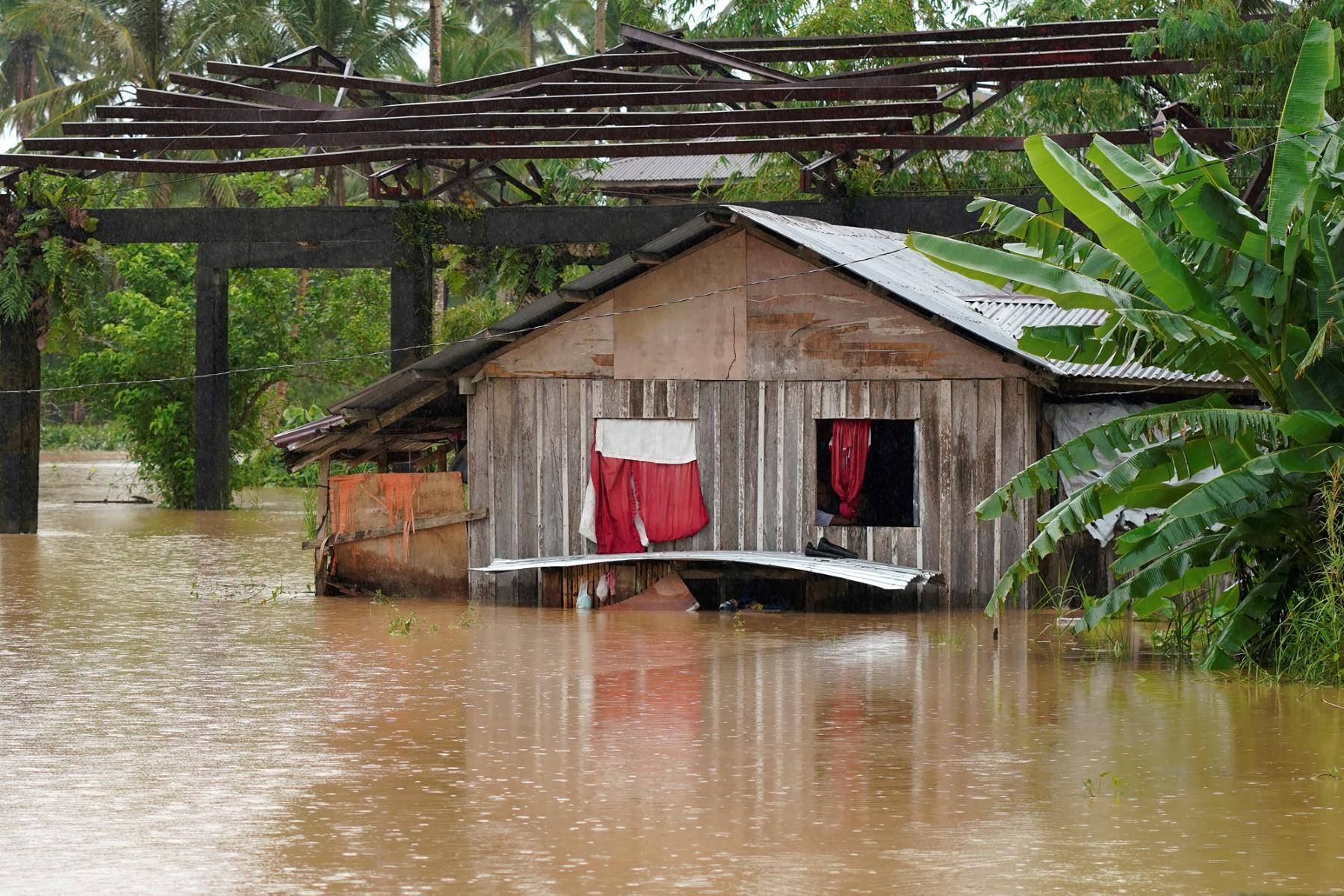 Residents look outside the window of their submerged house after heavy rains brought about by Tropical storm Agaton in Abuyog town, Leyte province, southern Philippines on April 11
