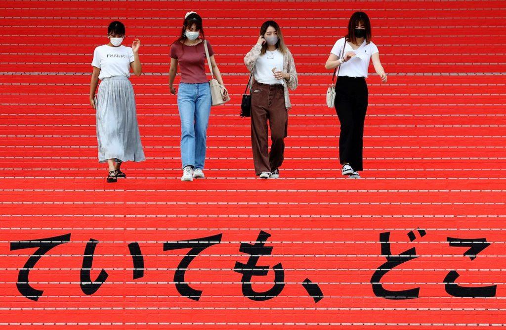 Women wearing protective masks walk down a flight of stairs bearing a slogan cheering on the Japanese team during Tokyo 2020 Olympic Games in Tokyo, Japan, Aug 7. Japan's health ministry says 637 technical interns quit because of pregnancy or childbirth between 2017 and 2020, including 47 who said they wished to continue the programme. Photo: Reuters