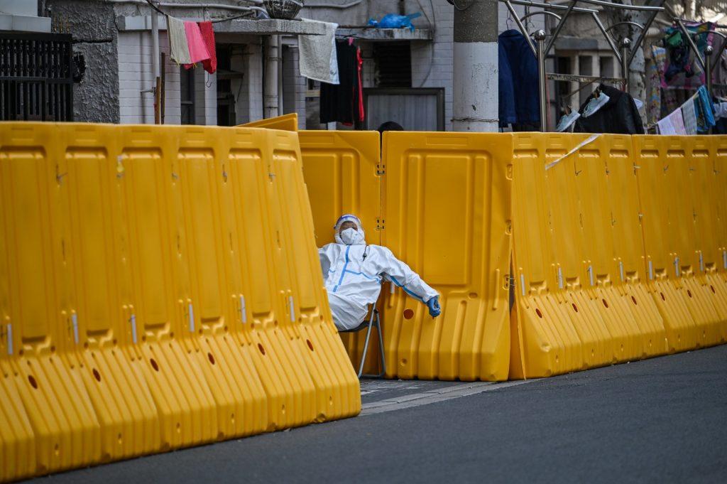 A worker wearing protective gear guards the entrance to a neighbourhood under lockdown as a measure against Covid-19, in Jing'an district, in Shanghai on March 29. Photo: AFP