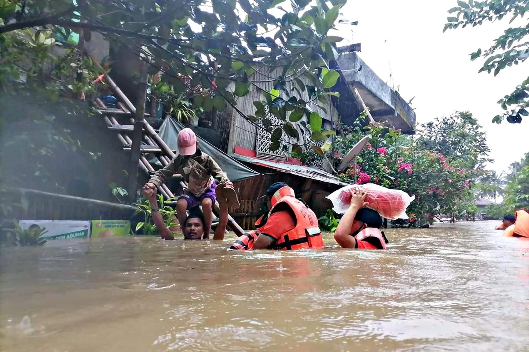 This handout photo taken on April 12, and received from the Philippine Coast Guard shows coast guard personnel evacuating local residents from their flooded homes in the town of Panitan, Capiz province as heavy rains brought on by Tropical Storm Megi inundated the area. Photo: AFP
