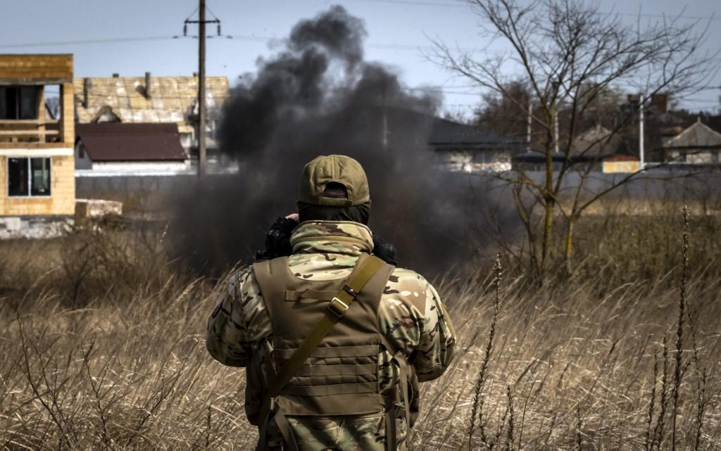 A member of a bomb disposal squad looks at smoke in a mine field near Brovary, northeast of Kyiv, on April 14, amid Russia's military invasion of Ukraine. Photo: AFP
