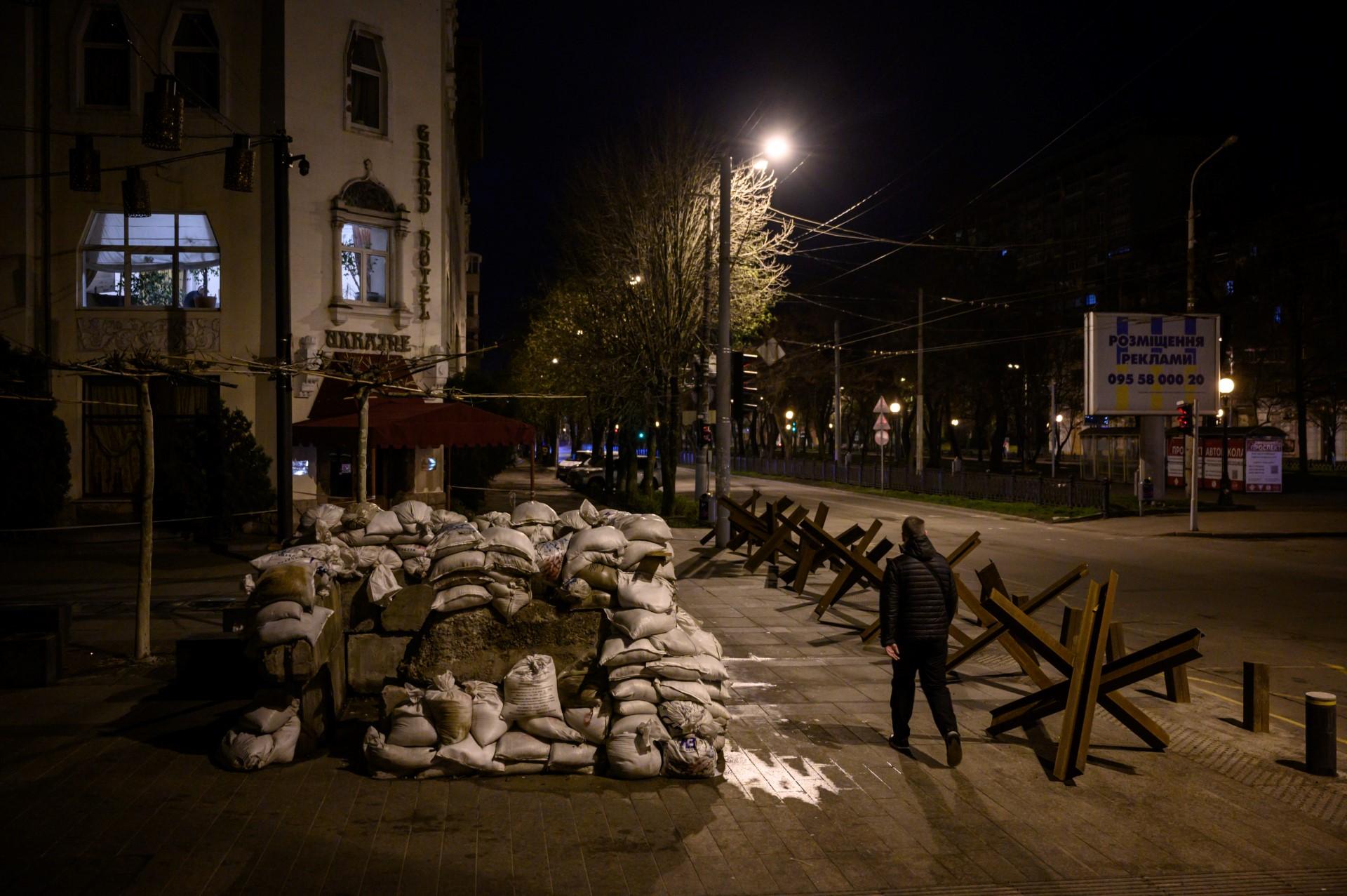 A pedestrian walks along a street past anti-tank obstacles shortly before a curfew in Dnipro on April 14, amid Russia's military invasion of Ukraine. Photo: AFP