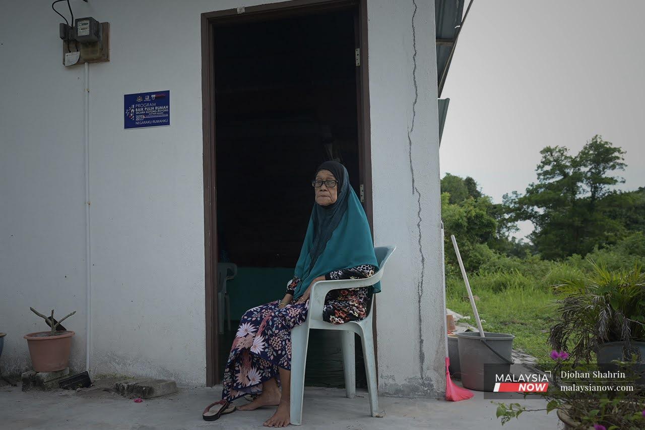 Sepinah Wahab sits on a plastic chair outside her house in Kampung Pasir Pandak in Sitiawan, Perak.
