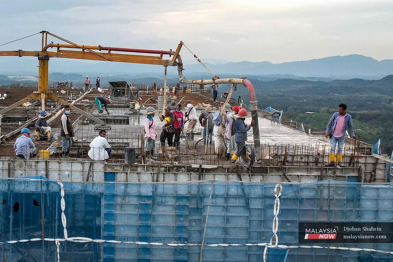 Foreign workers at a building construction site in Selangor. A syndicate is believed to have made a profit of RM2 million through fraudulent outsourcing activities for foreign labour.