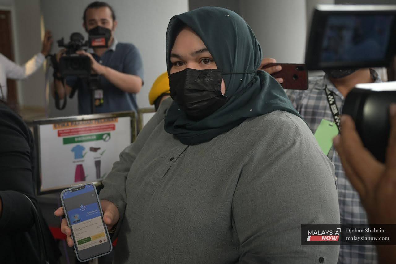 Rumah Bonda founder Siti Bainun Ahd Razali shows proof of her vaccination at the Kuala Lumpur court complex today.