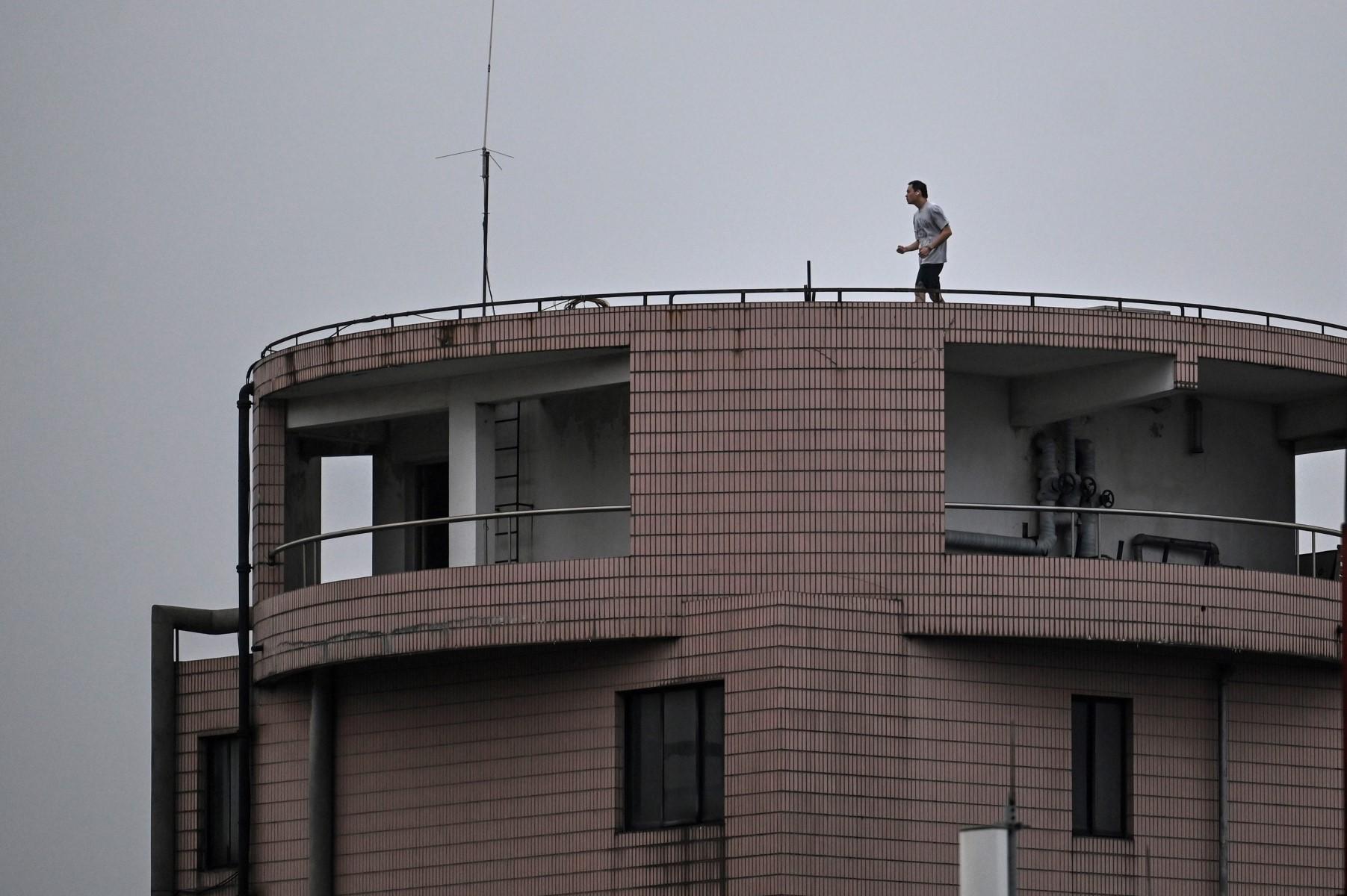 A man exercises on the rooftop of a residential building during the Covid-19 lockdown in the Jing'an district in Shanghai on April 20. Photo: AFP