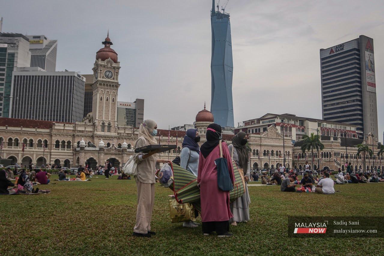 Orang ramai berkelah dan bersantai di Dataran Merdeka, Kuala Lumpur sambil menunggu waktu berbuka puasa.